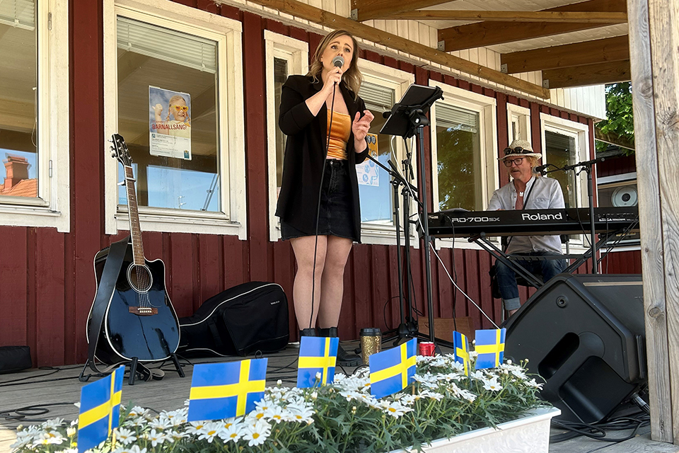Bilden visar en kvinna sjunga på en scen.