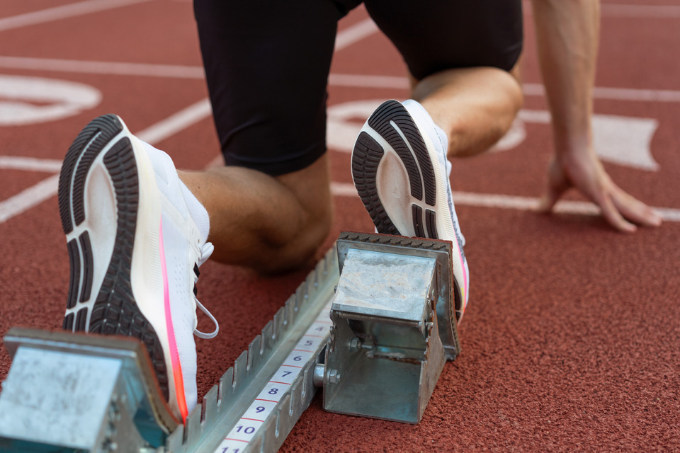 Närbild på skorna på en tävlingslöpare som står redo för start.