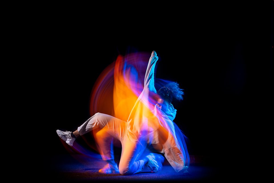 Dansare i neon mot svart bakgrund.